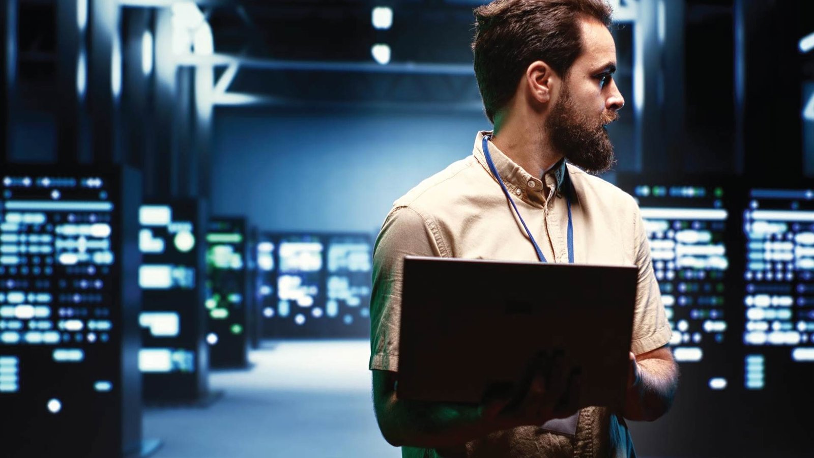 Technician using Render Networks platform to monitor data center infrastructure and fiber connectivity in a high-tech server environment.
