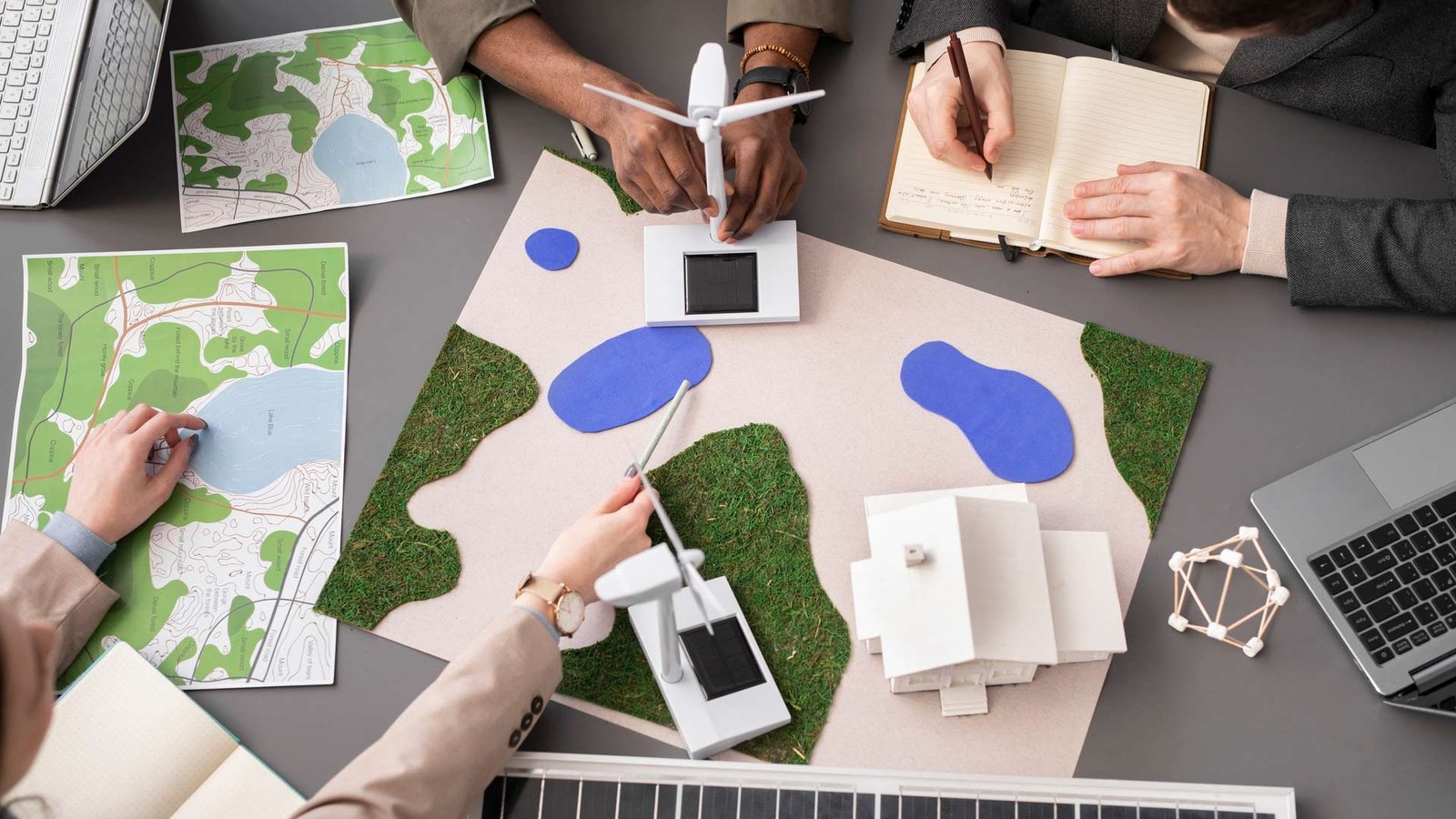 Vallisco team collaborating on sustainable architectural planning with wind turbines and eco-friendly building models.