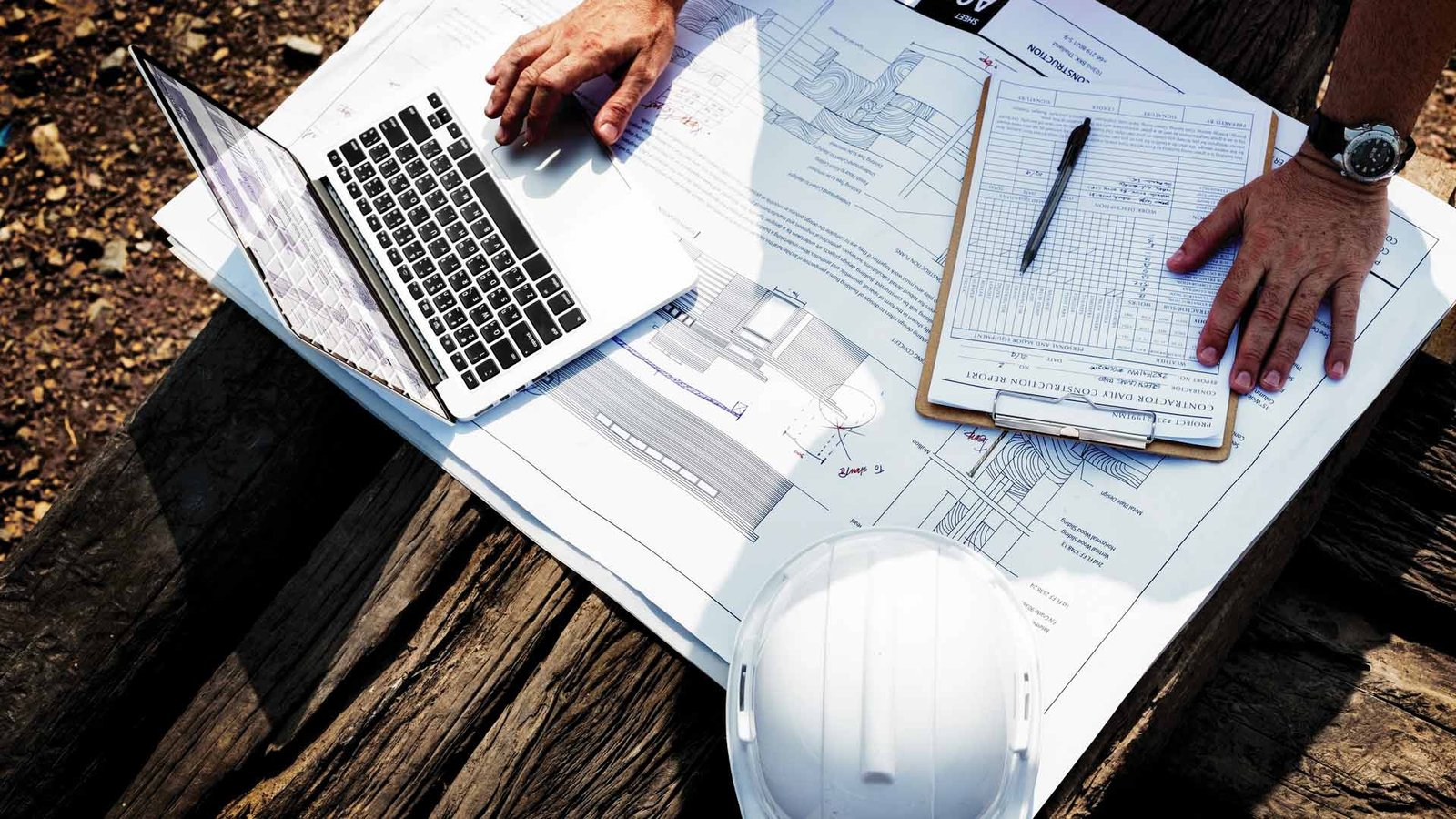 White Cap construction planning with legal documents, blueprints, and safety gear on-site.